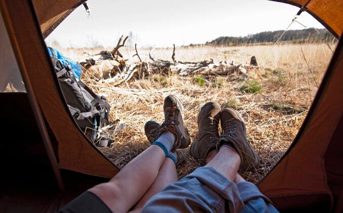 couple lying inside a tent with their feet outside Woking, England, United Kingdom CR_THHE200515D-395787-01,model released, Symbolfoto