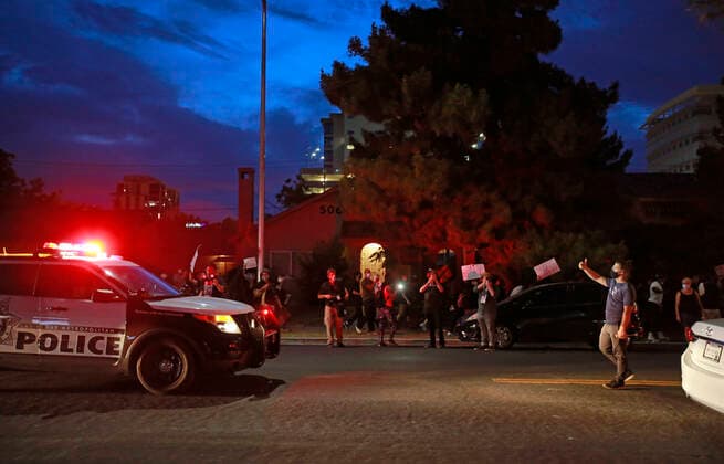 May 30, 2020, Las Vegas, Nevada, USA: A protester, right, flips his middle and thumb fingers at a police during a pause in the procession of a Black Lives Matter protest march Saturday, May 30, in downtown Las Vegas. The protest, which is one of many across the US this weekend, is in response to the recent death of Minneapolis man G. Floyd, who died in police custody. Las Vegas USA - ZUMAc98_ 20200530_sha_c98_562 Copyright: xRondaxChurchillx