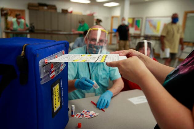 Bilder des Jahres 2020, News 06 Juni News Themen der Woche KW23 June 1, 2020, Bloomington, Indiana, United States: A voter drops a ballot into a box to cast her votes during an early voting in Monroe County..The 2020 Indiana Primary Election takes place. Bloomington United States - ZUMAs197 20200601_zaa_s197_249 Copyright: xJeremyxHoganx