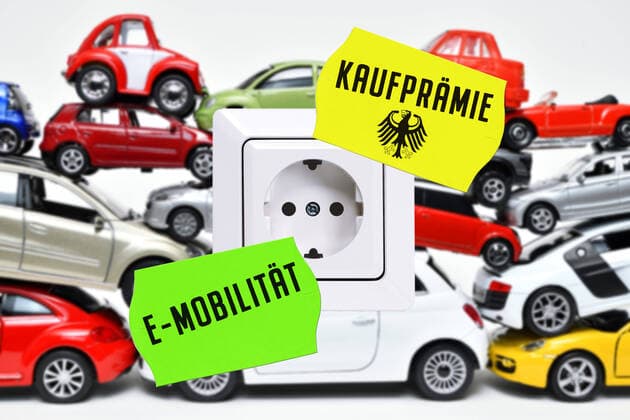 FOTOMONTAGE, Gestapelte Spielzeugautos mit Steckdose, Symbolfoto AutoprÃ¤mie fÃ¼r Elektroautos