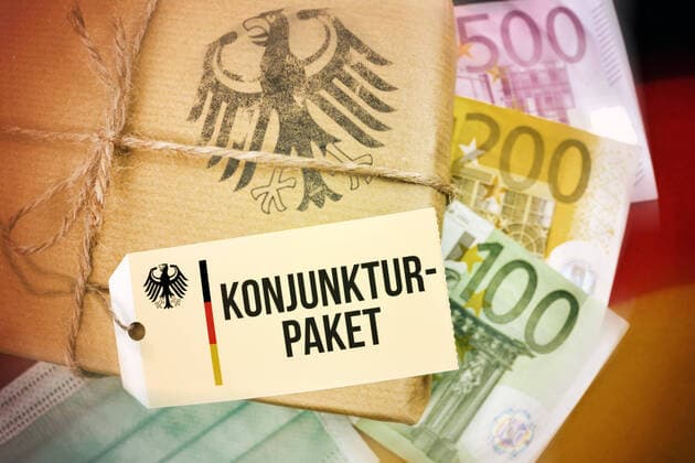 FOTOMONTAGE, Paket auf Deutschlandfahne mit Etikett und der Aufschrift Konjunkturpaket