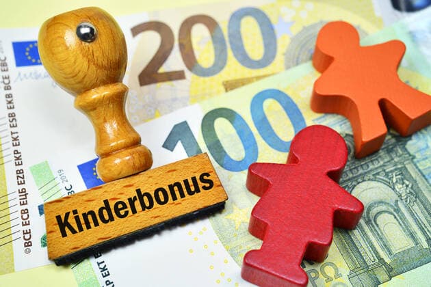 FOTOMONTAGE, Stempel mit Aufschrift Kinderbonus und Kinderfiguren auf Geldscheinen, Symbolfoto 300 Euro Kinderbonus