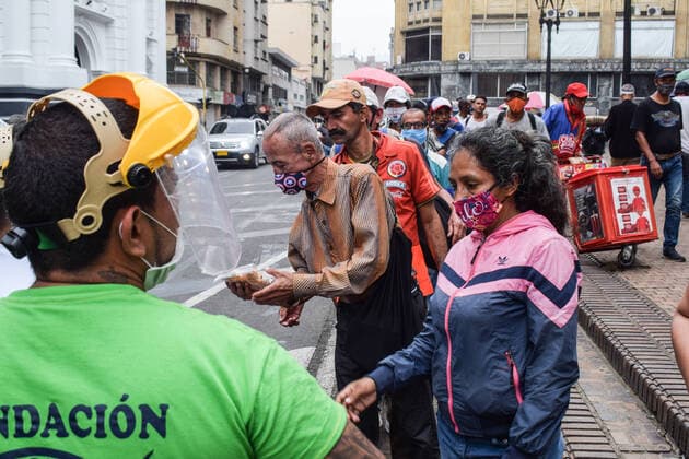 Members of Jesus Pescador de Hombres foundation giving food aid in the centre of Cali. The organisation prepares and distributes hundreds of daily meals to feed the homeless and Venezuelan migrants during the Coronavirus outbreak in Colombia Cali Colombia Copyright: xNanoxCalvox NN-PESC-COL-100