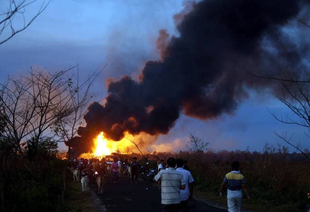 IMAGO Nature: Unsere Erde, Energiequellen, Erdgas (200610) -- ASSAM, June 10, 2020 -- People watch flames breaking out at the site of a gas well blowout at an oil field in Tinsukia district of Assam state, India, June 9, 2020. (Str Xinhua) INDIA-ASSAM-OIL FIELD-GAS WELL LEAKING-FIRE Stringer 