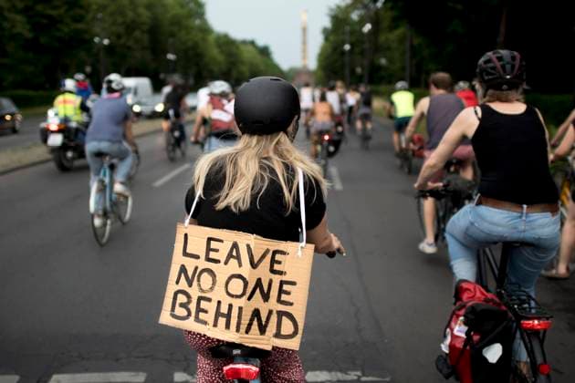 Seebruecke - Fahrraddemo DEU, Deutschland, Germany, Berlin, 13.06.2020 Demonstranten mit Fahrrad und Schild Leave No One Behind auf einer Fahrrademo von Seebruecke und anderer Initiativen auf der Kundgebung fuer Seenotrettung unter dem Motto 100 fuer das Fluechtlingslager Moria Rassismus toetet in unserer Gesellschaft in Berlin. Die Initiative fordert dass Berlin Gefluechtete aus Lage auf den griechischen Inseln befreit und dazu beim BMI endlich eine entsprechende Aufnahmeanordnung vorlegt. Aktionen gegen die Abschottungspolitik der EU in der Fluechtlingsfrage durch und spricht sich solidarisch mit den 70 Millionen Fluechtlingen aus, fuer legale Fluchtwege, eine Aenderung der deutschen Asylpolitik und bedingungsloses Bleiberecht. Protest