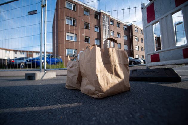 20.06.2020 - Coronavirus - Wohnsiedlung von Tönnies-Mitarbeitern in Quarantäne: Über laufende Entwicklungen des Corona-Ausbruchs von über 1000 Menschen im Fleischbetrieb Tönnies in Rheda-Wiedenbrück spricht die Geschäftsführung in Quarantäne. Im Kreis Gütersloh sind daher über 7000 Menschen in Quarantäne. Im Bild: Lebensmittel vor einem abgesperrten Haus. Foto: Noah Wedel, Verl Nordrhein-Westfalen Deutschland