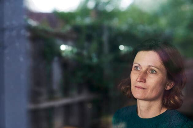 IMAGO Creative: Internationaler Frauenmonat, Gesundheit, Frauen in der Menopause Thoughtful mature woman looking through window at home model released Symbolfoto property released AUF00502