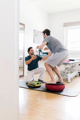 IMAGO Creative: NGO, Rehabilitation und Gesundheitswesen Physiotherapist assisting patient, practicing on balance trainer model released Symbolfoto property released DAWF01574