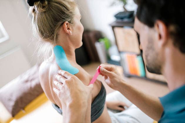 Physiotherapist applying therapeutic tape on patient s neck model released Symbolfoto property released DAWF01583