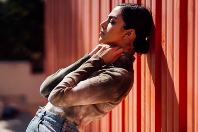 IMAGO Creative: Clickbait, Modetrends Side view of beautiful young woman leaning on red corrugated wall during sunny day model released Symbolfoto JSMF01473