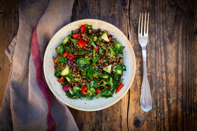 Bowl of vegan lentil salad with cucumbers, bell peppers and parsley LVF08921