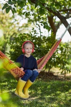 Girl with smartphone and headphones in hammock listening to music model released Symbolfoto property released MCF00840