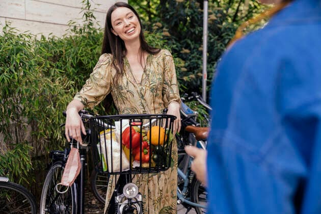 Two women with bicycle and face mask meeting in urban area model released Symbolfoto MFF05734