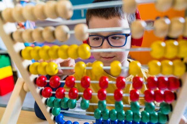 IMAGO Creative: NGO, Ausbildung für Kinder Boy calculating with colorful abacus at home model released Symbolfoto property released MGIF00962
