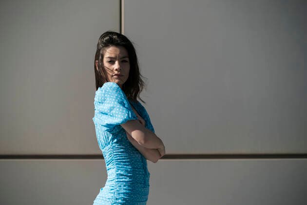 IMAGO Creative: Clickbait, Modetrends Confident young woman in blue mini dress standing arms crossed against gray wall model released Symbolfoto MTBF00422