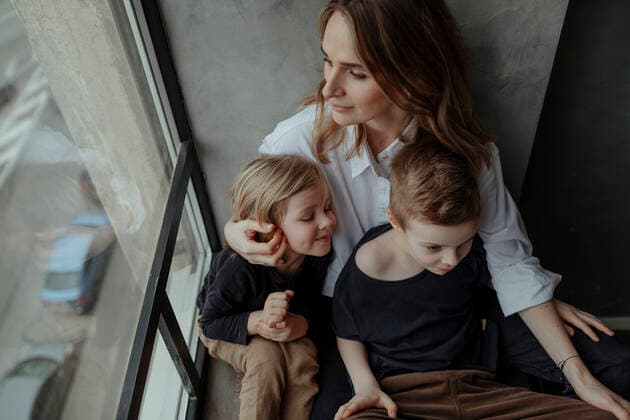 High angle view of woman sitting with sons by window at home model released Symbolfoto property released OGF00414