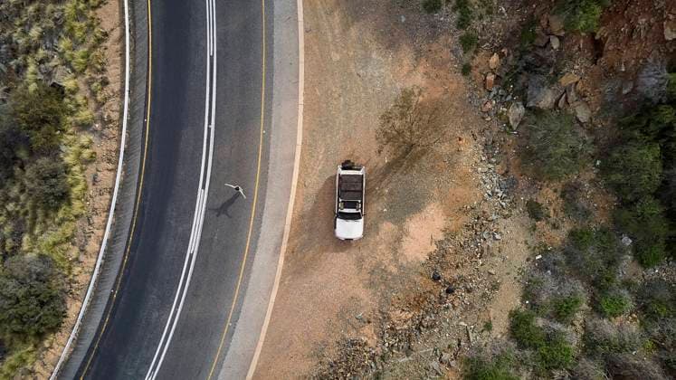 South Africa, Swellendam area, Aerial view of white 4x4 and woman in walking in tar road model released Symbolfoto VEGF01535