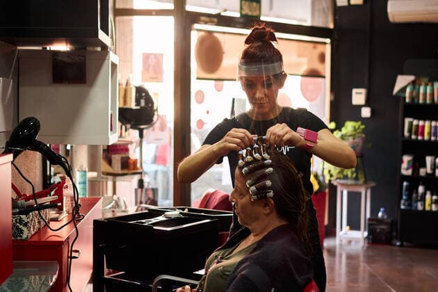 IMAGO Creative: Neue Aussichten Hairdresser combs a client with a face shield in her salon Villena, Valencian Community, Spain CR_CRBL200605-417601-01 ,model released, Symbolfoto