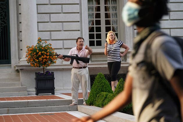 Bilder des Jahres 2020, News 06 Juni News Themen der Woche KW26 A husband and wife hold a pistol and semi-automatic rifle as protesters walk past their house en route to St. Louis Mayor Lyda Krewson s home during a protest march in St. Louis on Sunday, June 28, 2020. The man and woman greeted about 300 protesters, shouting as they broke down a gate in the neighborhood to march past their home. No shots were fired and the protesters moved on.  SLP2020062824 BILLxGREENBLATT