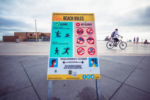Corona-Krise in den USA. Hinweisschild mit Regeln, wie man sich während Corona am Strand von Hermosa, Los Angeles, zu verhalten hat.