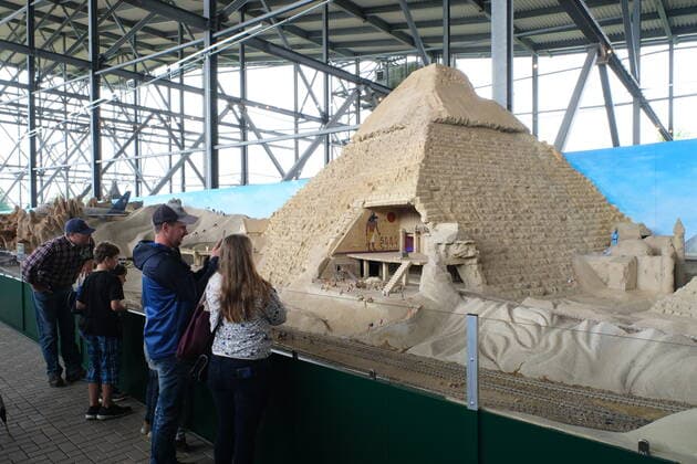 Snow Dome Modellbau Welten Bispingen Besucher vor ägyptischen Pyramiden. Die mit 12.000 Quadratmetern größte Modelleisenbahn der Welt hat heute in Bispingen eröffnet, mit 20 Kilometern verlegten Schienen sowie 500 Zügen und 50 Themenwelten stellen die Modellbau Welten einen neuen Weltrekord auf. Insgesamt 11 Millionen Euro wurden in den Ausbau investiert, die Modellbahn hat den Maßstab 1:22,5, Spurweite G. Bispingen liegt in Niedersachsen an der A7 zwischen Hamburg und Hannover 1.7.2020