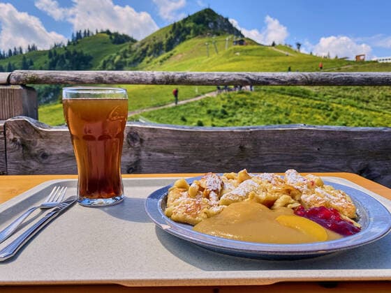 Tannheim, Tyrol Austria, July 01, 2020. A mountain biker enjoys a Kaiserschmarrn desert and the panoramic view from Gundhuette mountain hut on the Neunerkoepfle mountain.