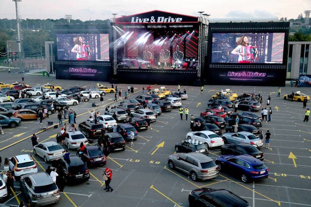 MOSCOW, RUSSIA - JULY 4, 2020:A drive-in concert by The Hatters gypsy folk rock band in Luzhniki. The concert, in which the sound is broadcast to the cars via FM radio, is part of LIVE&DRIVE, a series of live drive-in concerts organised by the TCI concert agency and SAV Entertainment Group during the pandemic of the novel coronavirus disease (COVID-19). Vyacheslav Prokofyev TASS  TS0DF286