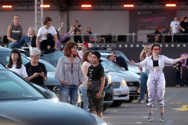 MOSCOW, RUSSIA - JULY 4, 2020: People at a drive-in concert by The Hatters gypsy folk rock band in Luzhniki. The concert, in which the sound is broadcast to the cars via FM radio, is part of LIVE&DRIVE, a series of live drive-in concerts organised by the TCI concert agency and SAV Entertainment Group during the pandemic of the novel coronavirus disease (COVID-19). Vyacheslav Prokofyev TASS  TS0DF288