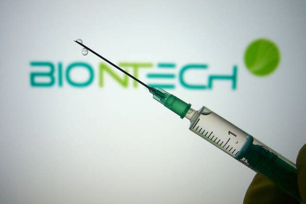 Themenbild,Symbolfoto:Corona Impfstoff. Eine Hand in Gummihandschuhe gehuellt haelt eine Einwegspritze mit Impfstoff zur Injektion mit einer Kanuele. BIONTECH Biotechnologie Unternehmen.