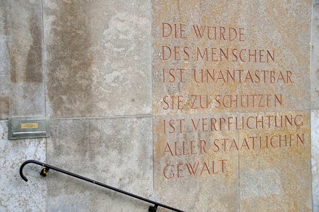 Der Fritz-Bauer-Platz in der Innenstadt von Braunschweig. Er trägt seit 2012 den Namen des früheren Generalstaatsanwalts am Oberlandesgericht Braunschweig, der 1956 als Generalstaatsanwalt nach Frankfurt am Main wechselte und dort die Anklage im Auschwitz-Prozess erhob. An dem Platz residiert die Generalstaatsanwaltschaft Braunschweig. Ein Relief an der Hausfassade zitiert den Grundgesetz-Artikel 1: Die Würde des Menschen ist unantastbar. Sie zu achten und zu schützen ist Verpflichtung aller staatlichen Gewalt. *** The Fritz Bauer Platz in the centre of Braunschweig Since 2012, it has borne the name of the former Attorney General at the Braunschweig Higher Regional Court, who moved to Frankfurt am Main as Attorney General in 1956 and t