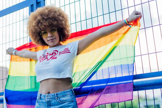 IMAGO Creative: Pride Month 2022, Engagement der Jugendlichen woman holding her gay pride flag on a bridge Madrid, Community of Madrid, Spain CR_IVAR200703-442655-01 ,model released, Symbolfoto