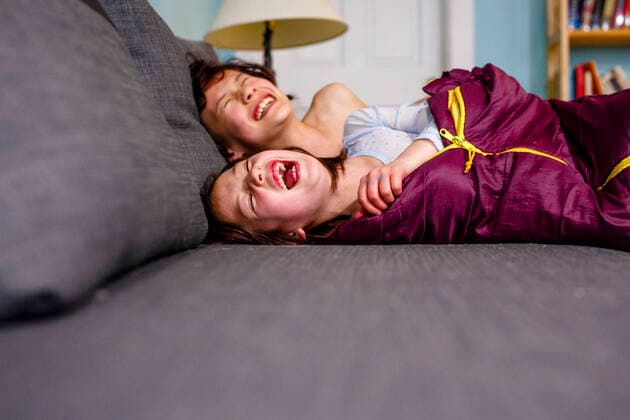 two happy children lay on couch together laughing out loud with joy Columbus, OH, United States CR_RETI200701A-380927-01 ,model released, Symbolfoto