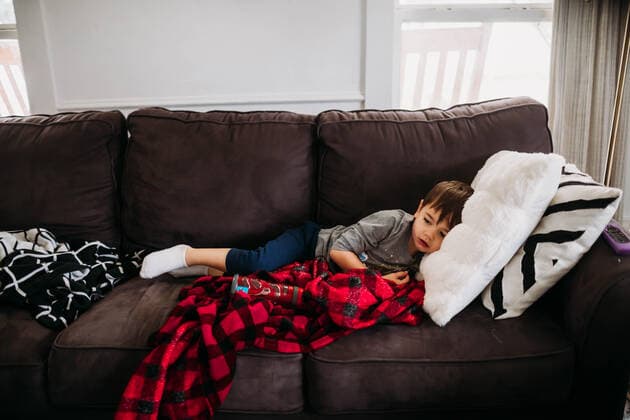 Young boy laying on couch in living room while sick with flu Fort Worth, TX, United States CR_TAHI200701-413812-01 ,model released, Symbolfoto