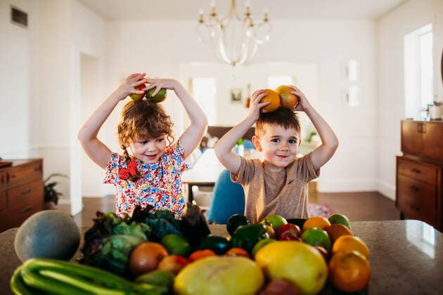 Young boy and girl sitting at kitchen counter playing with fruit Fort Worth, TX, United States CR_TAHI200701-413943-01 ,model released, Symbolfoto