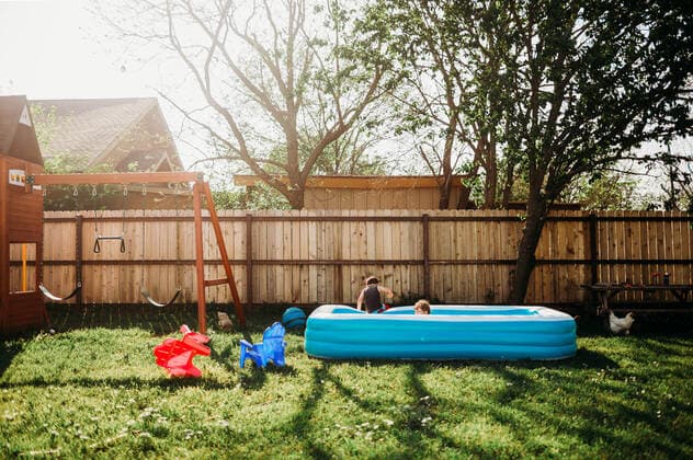 Two young kids swimming in backyard pool by swing set Fort Worth, TX, United States CR_TAHI200701-413968-01 ,model released, Symbolfoto