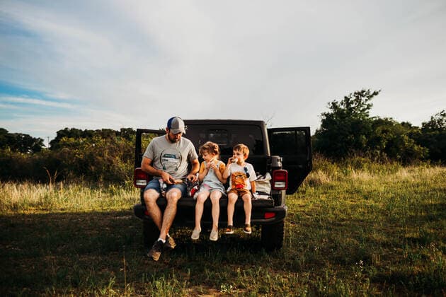 Dad and two kids having a picnic on truck tailgate Fort Worth, TX, United States CR_TAHI200701-413989-01 ,model released, Symbolfoto