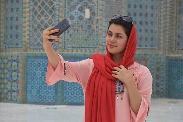 (200712) -- BALKH, July 12, 2020 -- A woman takes a selfie with the background of the Blue Mosque in Mazar-i-Sharif, capital of Balkh province, northern Afghanistan, July 11, 2020. After a five-month shutdown due to the impact of COVID-19 pandemic, the Blue Mosque has reopened to the public recently. (Photo by Xinhua) AFGHANISTAN-BALKH-REOPEN-BLUE MOSQUE-COVID-19 KawaxBasharat 