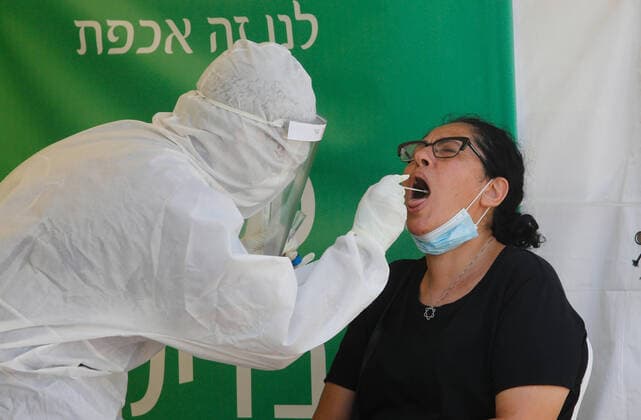 (200713) -- LOD (ISRAEL), July 13, 2020 (Xinhua) -- A medical worker collects a swab from a woman for a COVID-19 test in Lod, central Israel, on July 13, 2020. Israel s Ministry of Health has reported 1,962 new coronavirus cases on Monday, bringing the total cases to 40,632. (Photo by Gil Cohen Magen Xinhua) ISRAEL-LOD-COVID-19-CASES 