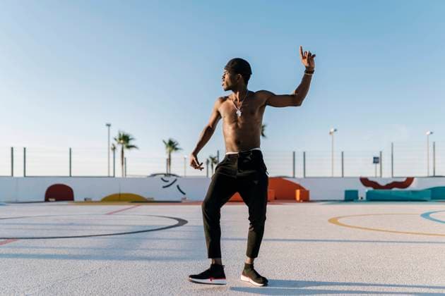 IMAGO Creative, Jahreszeit Sommer, Sommer in der Stadt IMAGO Creative: Neue Aussichten Shirtless young man dancing against clear sky in sports court during sunny day model released Symbolfoto EGAF00301