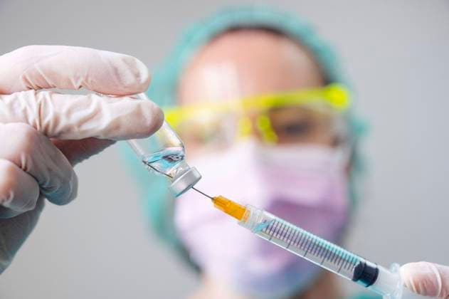 Close-up of dentist s hands holding coronavirus vaccine and syringe in clinic model released Symbolfoto property released JCMF00871