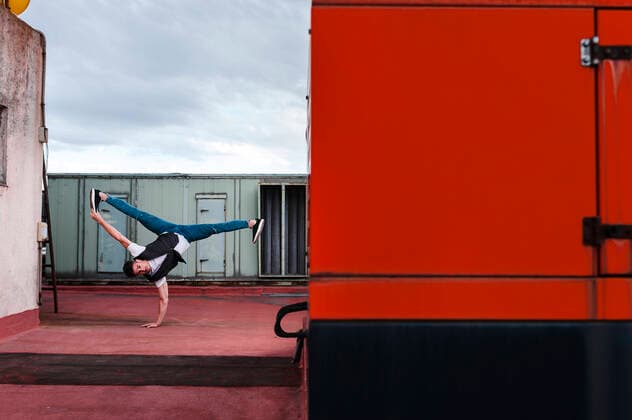 Male dancer breakdancing on abandoned building terrace against cloudy sky model released Symbolfoto JMPF00194