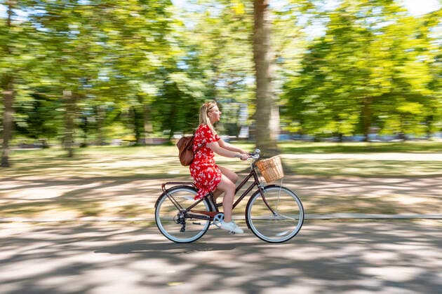 Blurred motion of woman riding bicycle on footpath at public park model released Symbolfoto  WPEF03064