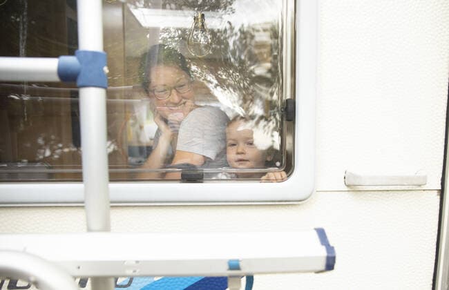 Mutter und Kind schauen aus einem Wohnanhaenger. Bonn Deutschland *** Mother and child looking out of a residential trailer Bonn Germany Copyright: xUtexGrabowsky photothek.netx