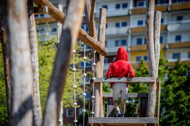 IMAGO Creative: Gesellschaft, Armut 31. Juli 2020: Leipzig (Sachsen), Stadtteil Gruenau: Ein Kind steht auf einem Spielplatz vor einem Plattenbau in Leipzig-Gruenau. *** 31 July 2020 Leipzig Saxony , Gruenau district A child is standing on a playground in front of a prefabricated building in Leipzig Gruenau
