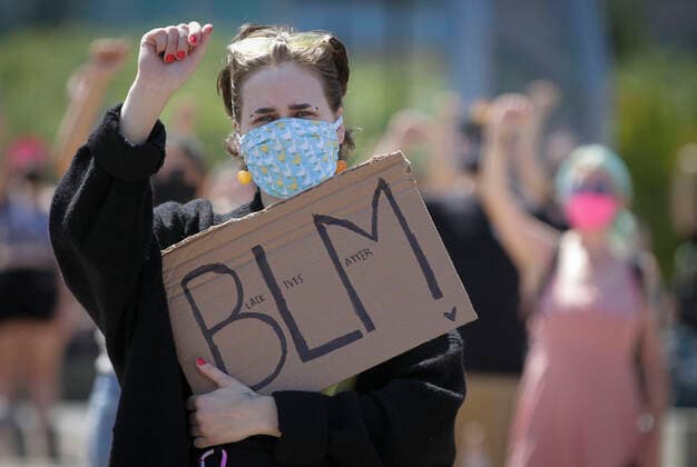 (200801) -- VANCOUVER, Aug. 1, 2020 -- A protestor carries a sign while participating in the Emancipation Day march in Vancouver, British Columbia, Canada, August 1, 2020. In conjunction with the Black Lives Matter protest, thousands of people took part in a march to commemorate the Emancipation Day in Canada, which is marked on August 1. (Photo by Xinhua) CANADA-VANCOUVER-EMANCIPATION DAY MARCH LiangxSen 