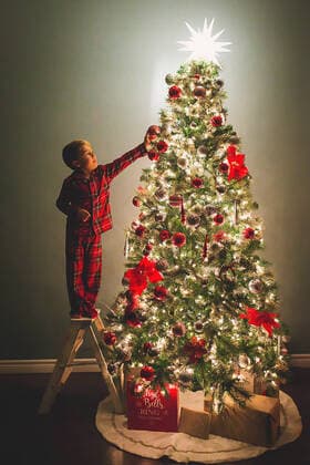 Boy hanging ornaments on Christmas Tree at night time San Diego, CA, United States CR_CHDO200731B-464553-01 ,model released, Symbolfoto