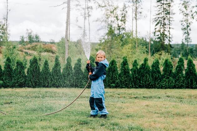 IMAGO Creative: Klimawandel - Umwelterziehung IMAGO Creative: Klimawandel - Grüne Erholung boy standing with a hose spraying water at home in the yard Norrtälje, Stockholm County, Sweden CR_RABE200715-442559-01 ,model released, Symbolfoto