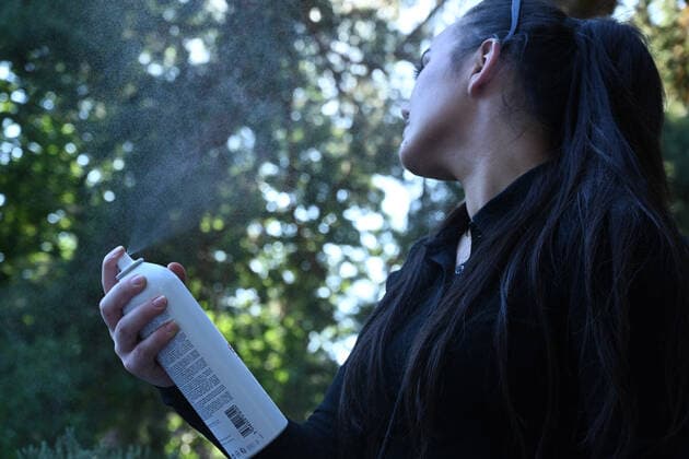 Symbolbild- junge Frau (model released) erfrischt sich mit Wasser-Spray bei hohen Temperaturen