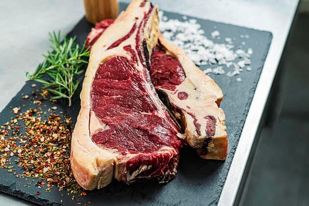 Raw steak, rosemary and salt on a serving board Novales, Cantabria, Spain CR_JOAN200803-463151-01 ,property released