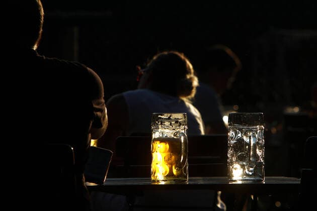 Maß Bier leuchtet in der tiefstehende n Abendsonne im Biergarten Königlicher Hirschgarten in München, Bayern, Deutschland